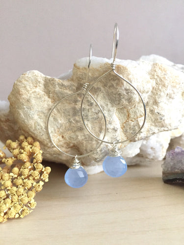 Handmade hoop earrings with a light blue gemstone drop