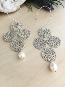 Delicate and lacy woven sterling silver earrings in a quaterfoil design and a feshwater pearl drop