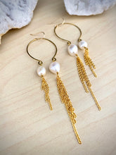 Load image into Gallery viewer, Close up of gold inverted pearl statement  earrings with long chain tassels 