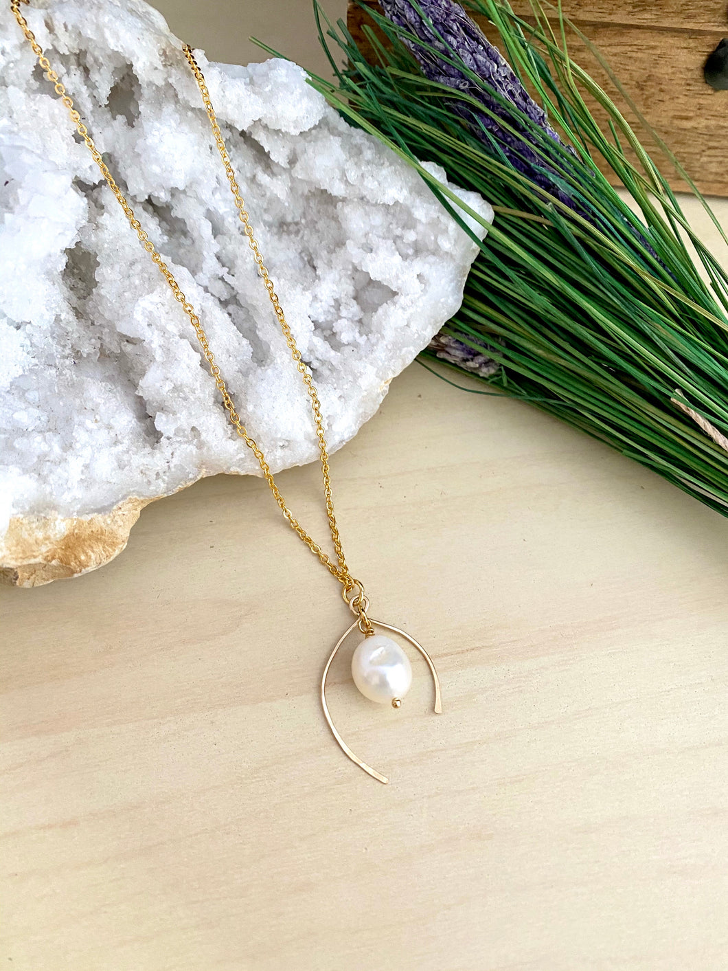 Wish bone shaped pendant necklace made from 14k gold fill wire and accompanied by a white freshwater pearl drop 